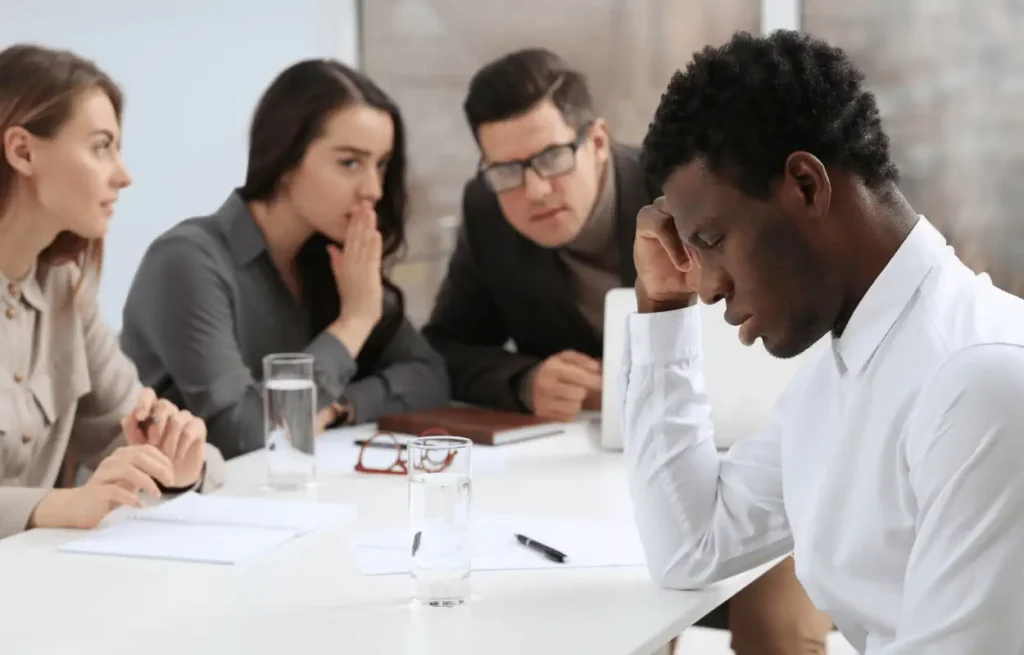 Image of coworkers discriminating against an employee.