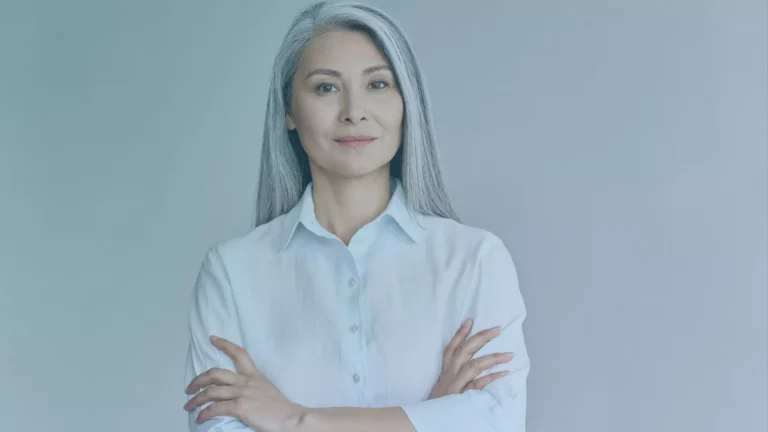 An older lady is crossing her arms and smiling, after winning a case about age discrimination from her Oregon employment.