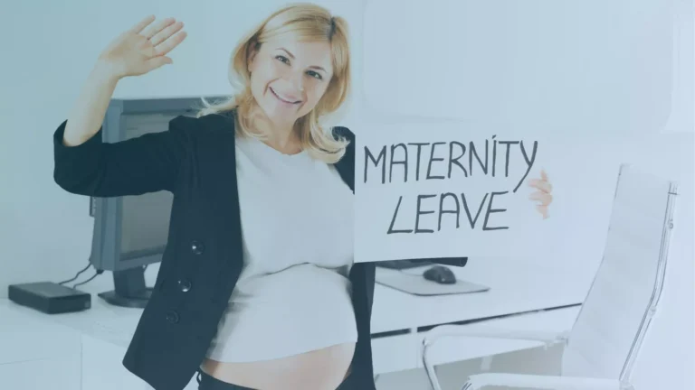 Pregnant employee researching maternity leave rights in Oregon, holding up a sign in celebration.