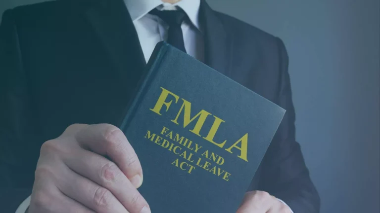 FMLA attorney holding Family and Medical Leave Act booklet related to interference claims.