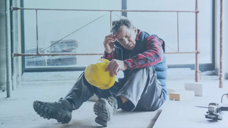 Construction worker sitting on the floor after being injured and filing an unsafe work environment lawsuit.