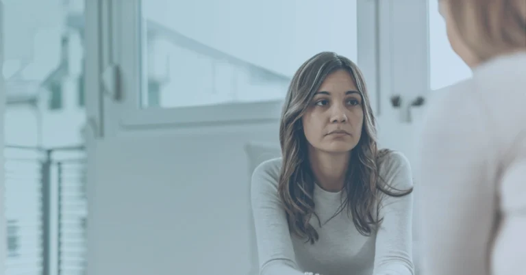 Employee discussing a workplace mental health concern with a professional during a confidential meeting.
