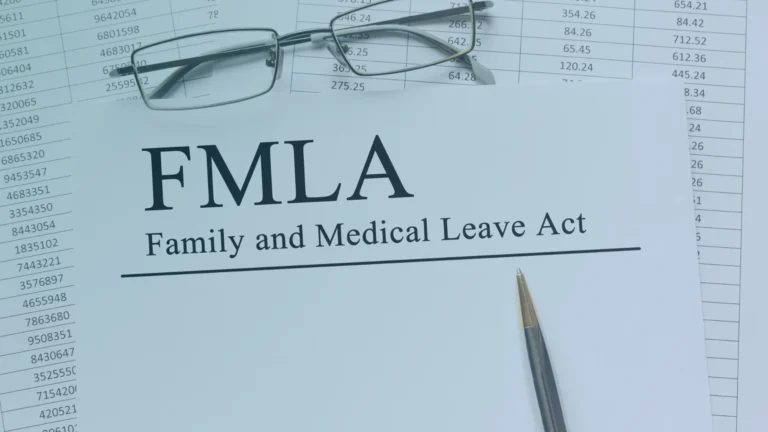 FMLA Family and Medical Leave Act document with eyeglasses and a pen, representing employee medical leave rights and workplace discrimination protections.