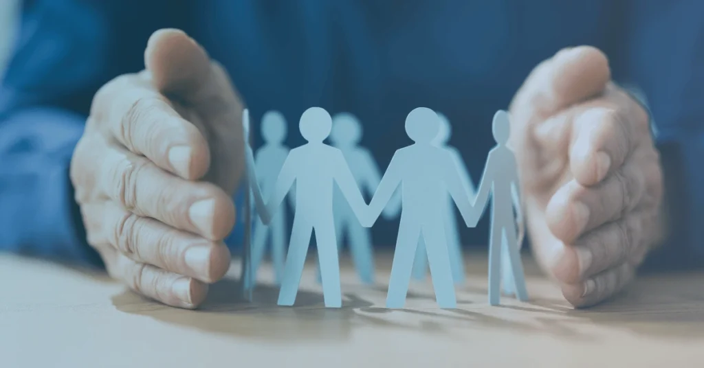 Paper employee figures protected by a pair of hands, representing workplace leave rights and employment protections available to Oregon workers.